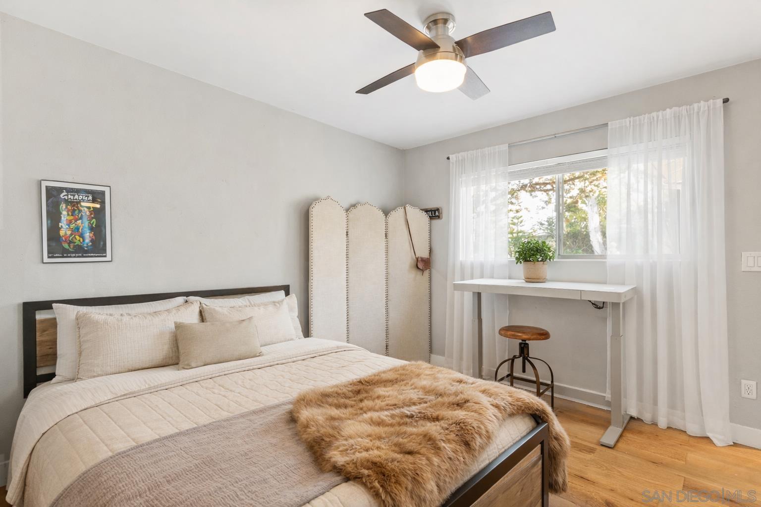 Secondary bedroom with hardwood floors and natural light