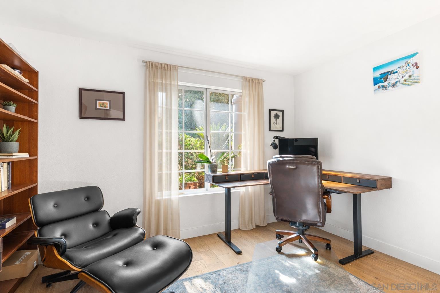 Home office with built-in shelving, Eames lounge and garden view